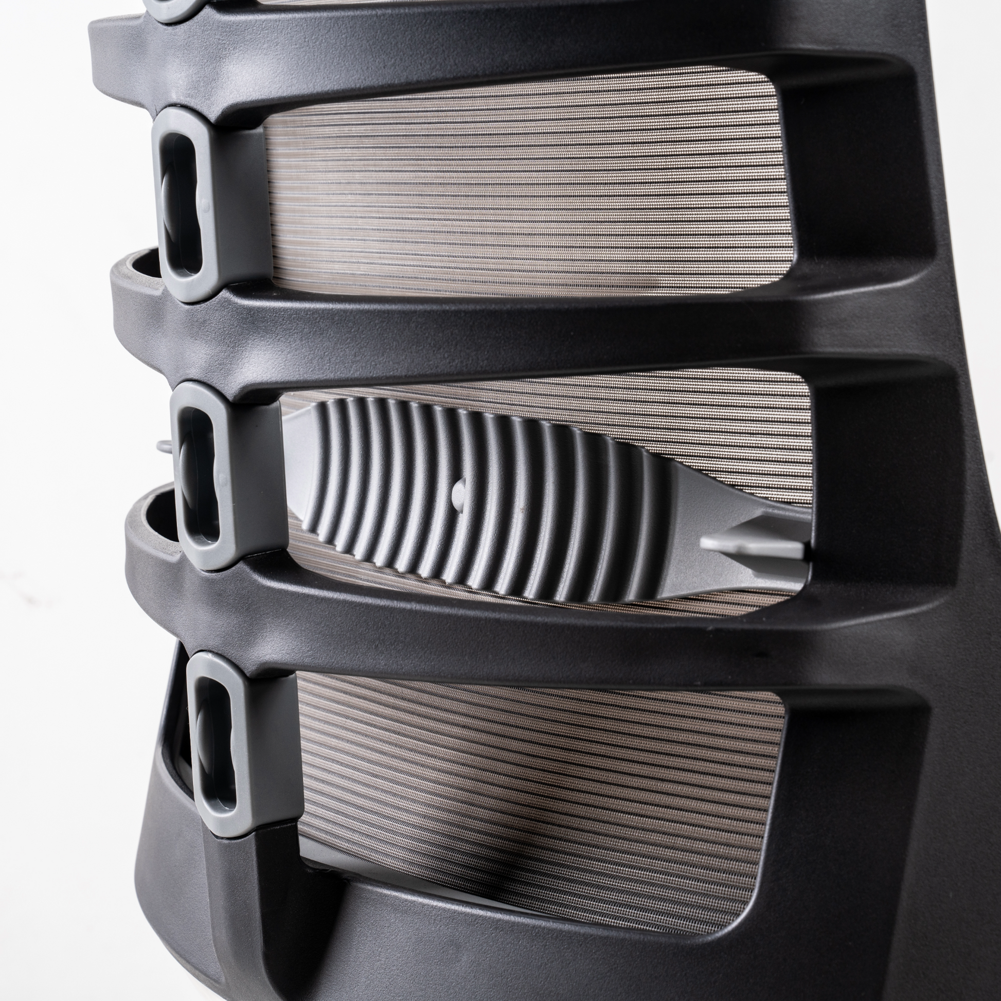 Backrest: Spinal joints  of thermoplastic elastomer in  grey colour. Polyelastomer/Nylon/ Polyester mesh in Jet grey colour.